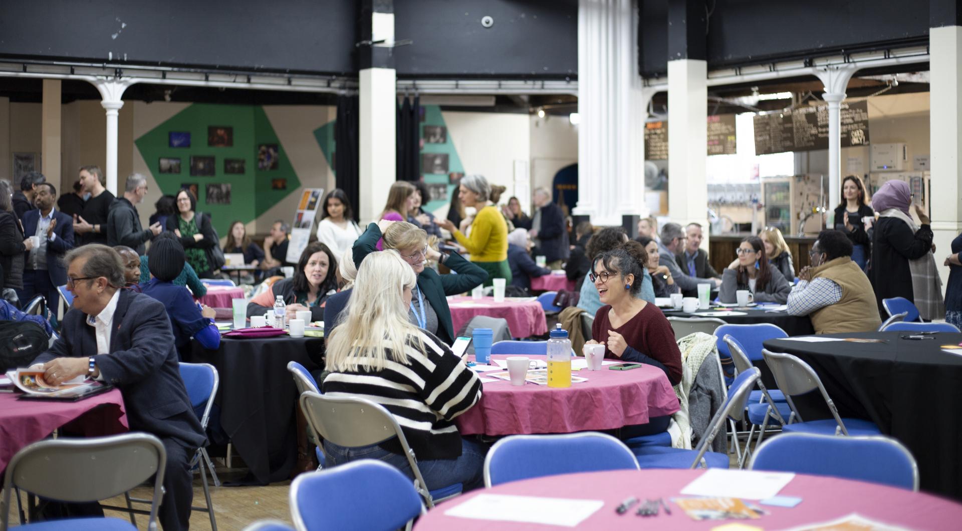 Photo of people around tables at ACH event